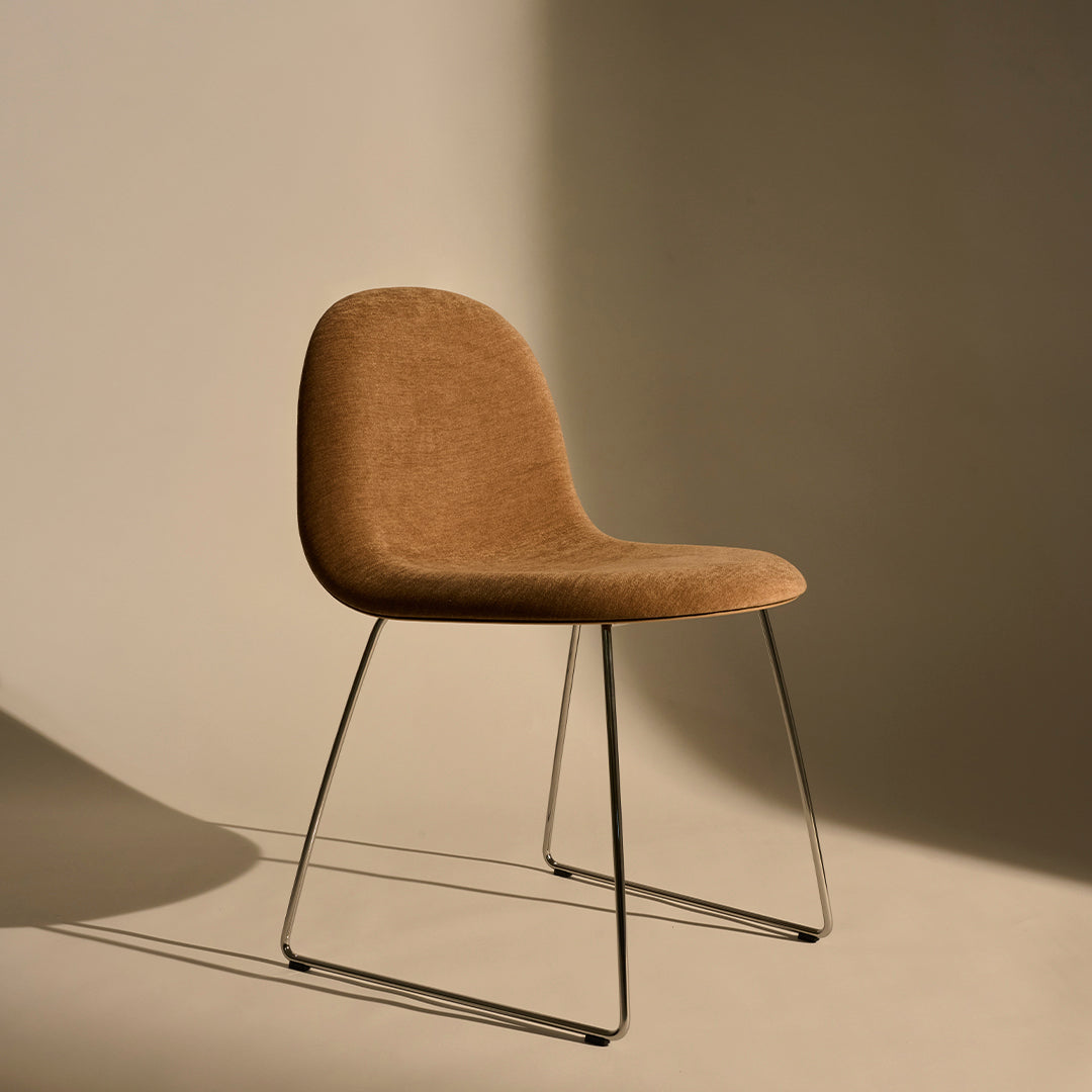 Brown upholstered chair with sleek metal legs on a neutral background, showcasing texture and minimalistic design.