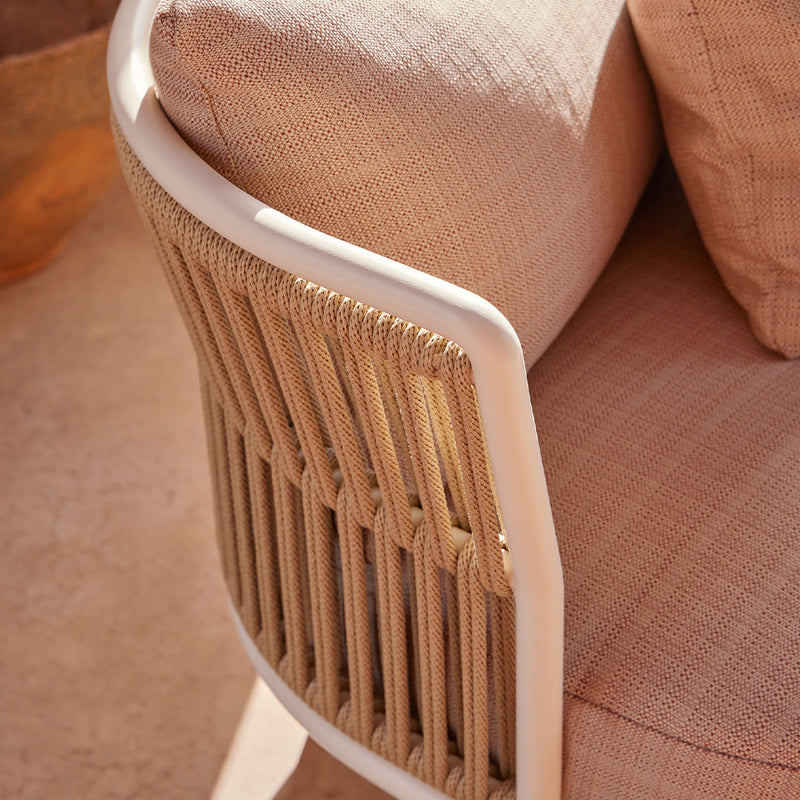 Beige and cream cushions with a textured pattern, set against a natural woven backrest design in a modern chair.
