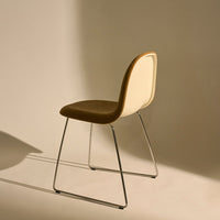 Brown and cream chair with soft textures, sleek chrome legs, and a minimalist design on a neutral backdrop.