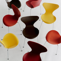 Colorful mid-century chairs in red, yellow, brown, and orange with sleek, modern designs. Perfect for stylish interiors.
