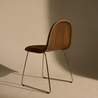 Stylish brown wooden chair with a sleek chrome base, featuring smooth curves and minimalistic design.