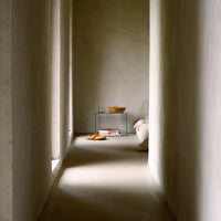 Neutral gray walls with soft cream tones and warm wooden accents create a serene, minimalist hallway aesthetic.