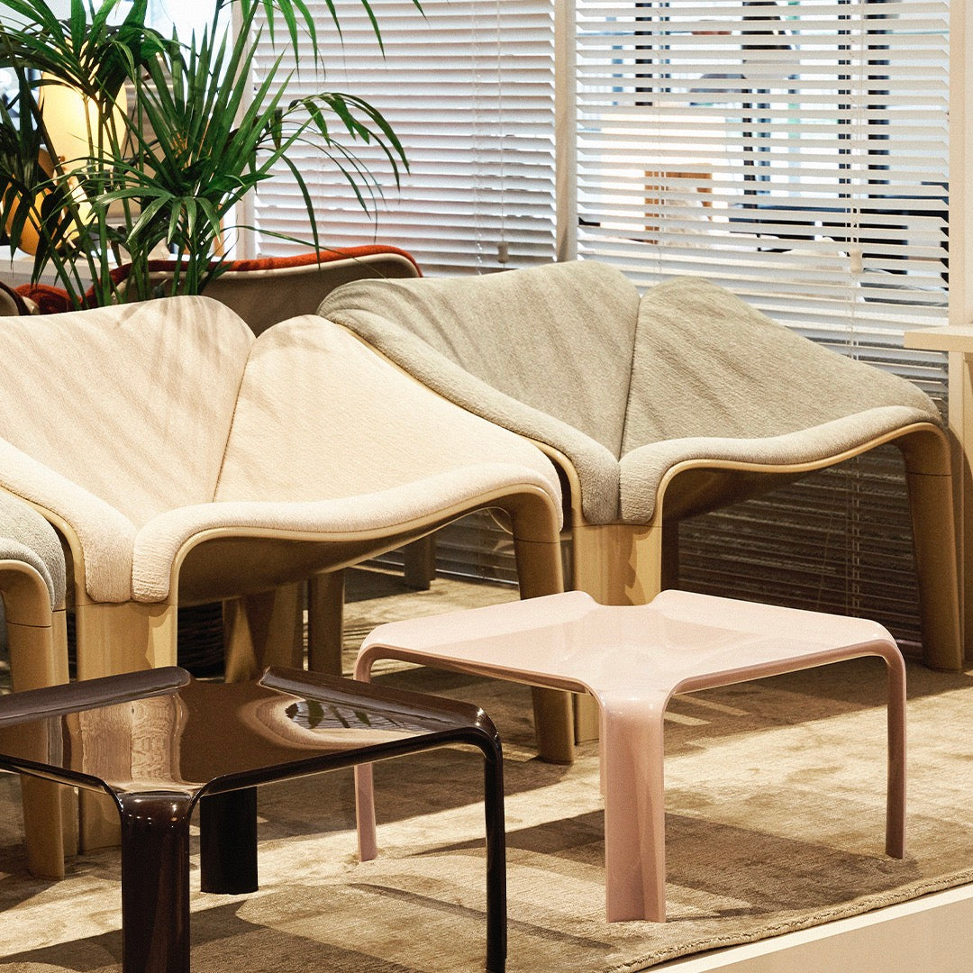 Stylish modern chairs in beige, gray, and brown tones with a pink table, set against a light, airy backdrop.