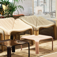 Stylish modern chairs in beige, gray, and brown tones with a pink table, set against a light, airy backdrop.