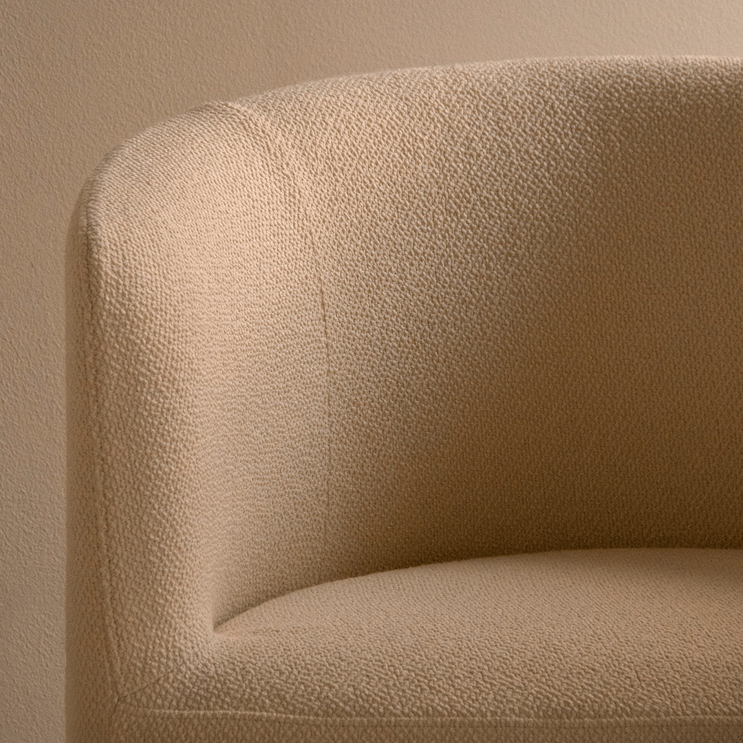 Beige textured fabric armchair with a soft, muted finish, perfect for a warm, modern decor.