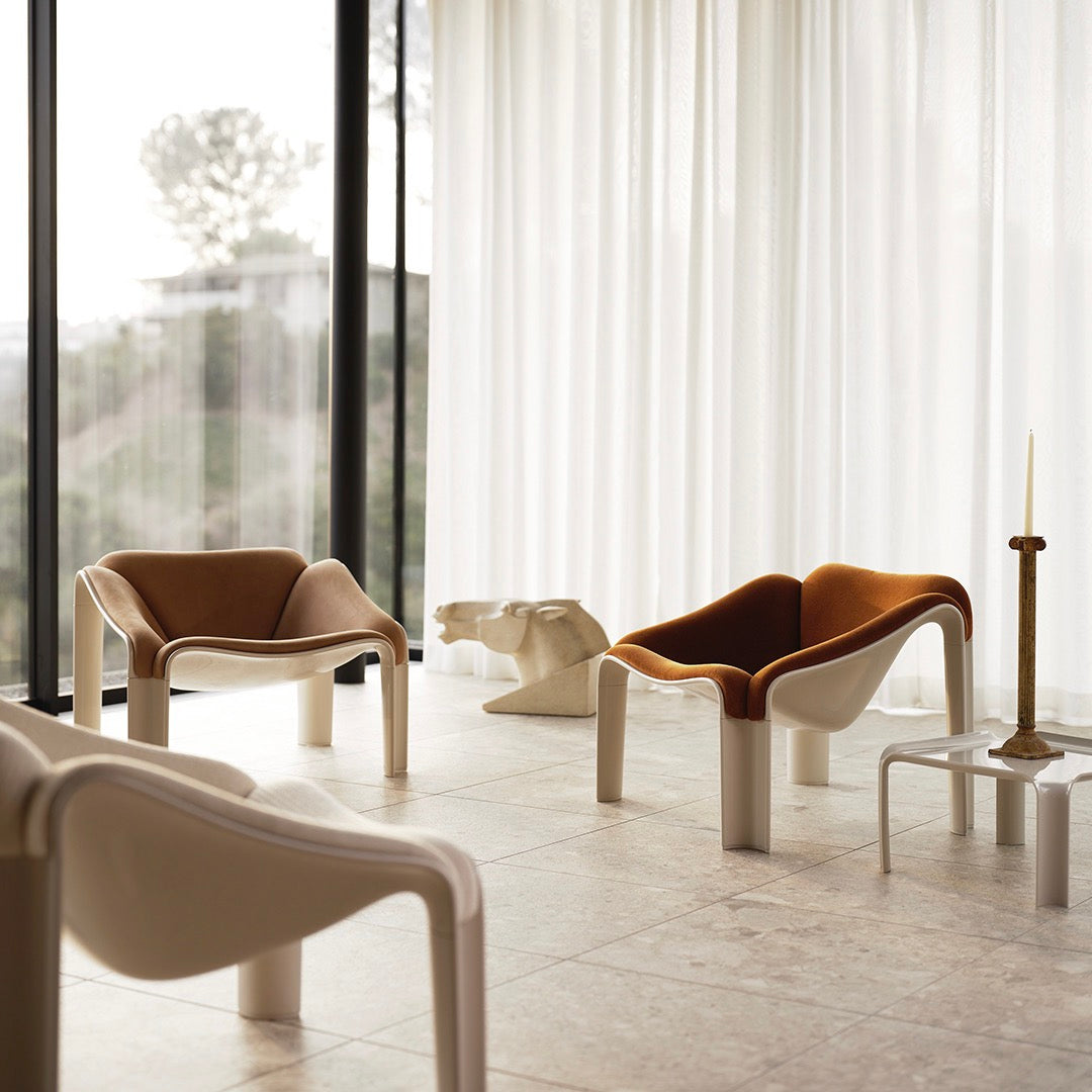 Modern chairs featuring warm terracotta and cream colors with smooth, curved patterns in a stylish interior setting.