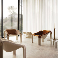 Modern chairs featuring warm terracotta and cream colors with smooth, curved patterns in a stylish interior setting.