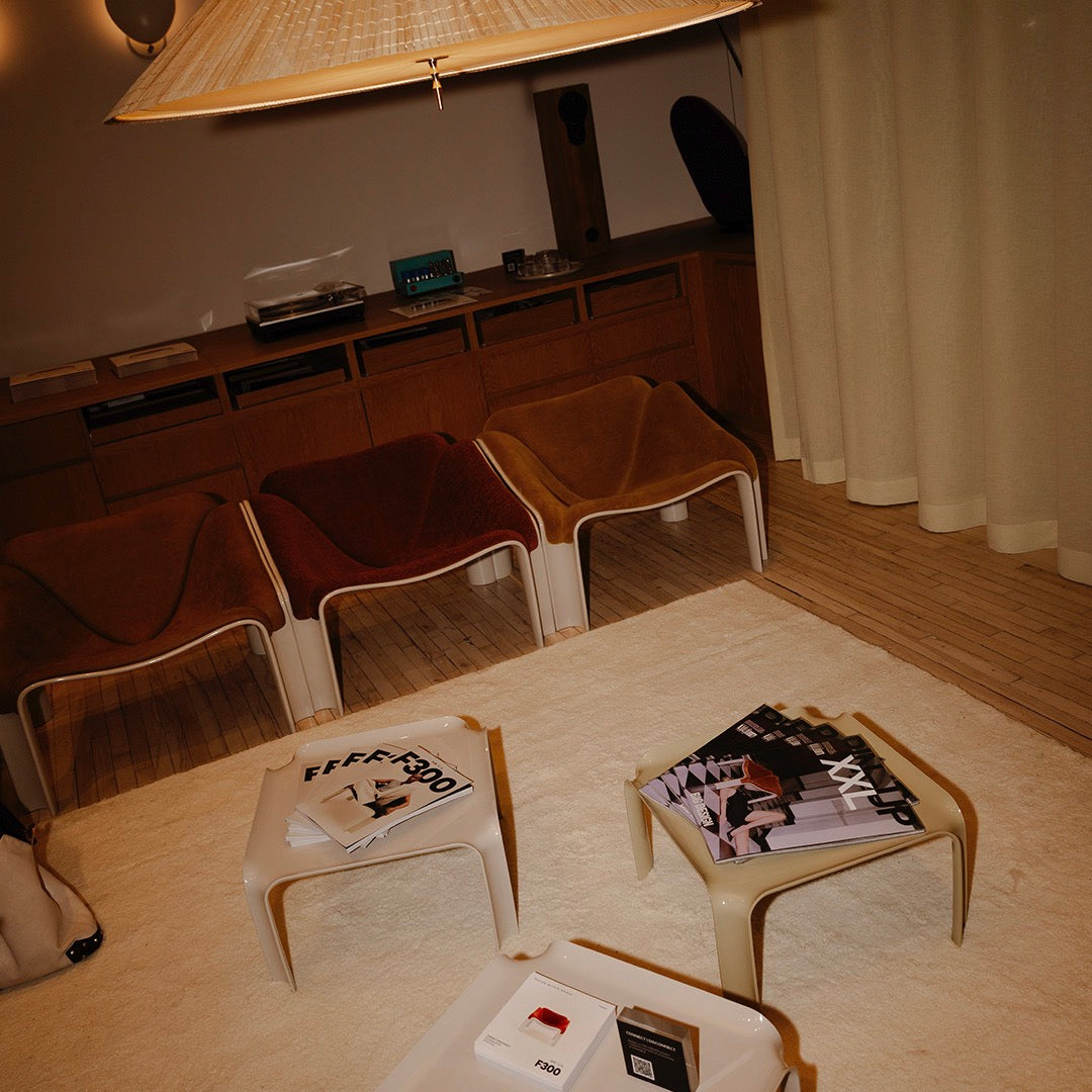 "Modern lounge area with earthy tones, textured fabric chairs, and geometric patterned magazines on light-colored tables."