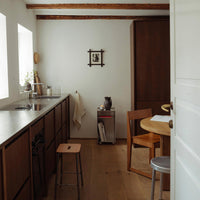 Modern kitchen with warm wooden tones, sleek gray countertop, and light walls, creating an inviting atmosphere.