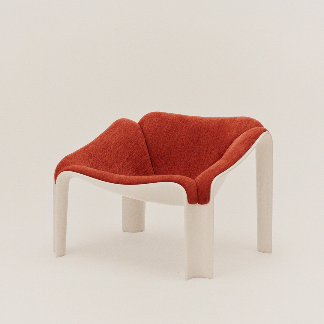 Red and white modern chair with a unique curved design and textured upholstery in a contemporary setting.
