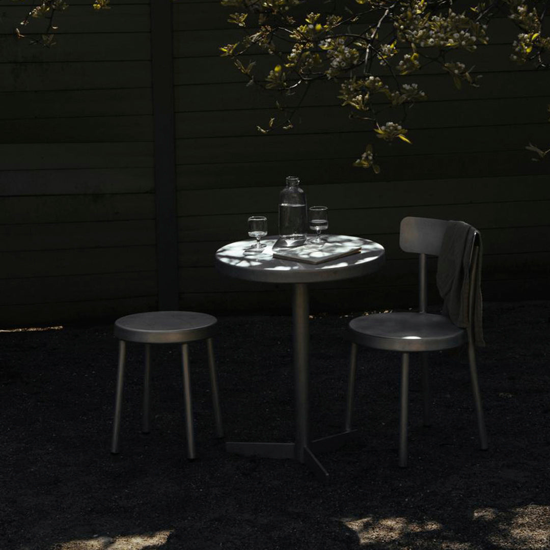 "Minimalist black and gray table set with subtle patterns, accentuated by natural shadows and soft lighting."