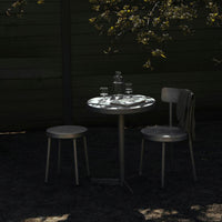 "Minimalist black and gray table set with subtle patterns, accentuated by natural shadows and soft lighting."