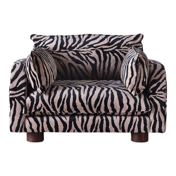 Black and beige zebra-striped armchair with matching accent pillows, perfect for bold decor.