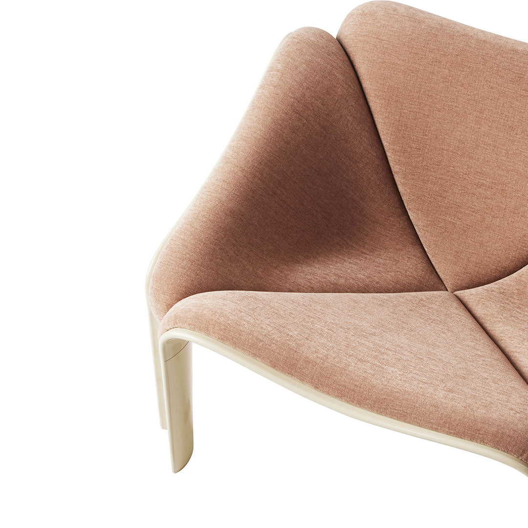Soft pink upholstery with a subtle texture, featuring a modern, curved design and light wood accents.