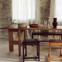 Elegant wooden table with neutral tones, featuring smooth, natural textures, complemented by earthy bowls and glassware.