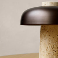"Bronze lamp shade atop a textured beige base, creating a modern minimalist aesthetic."