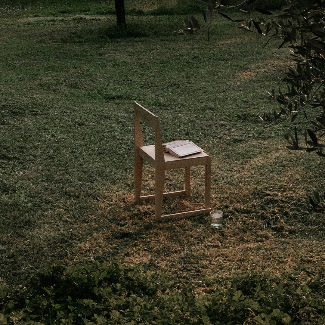 Light wooden chair on green grass, accented by soft natural tones and minimalistic design. Ideal for outdoor settings.