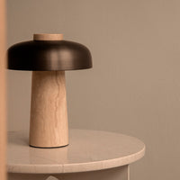 Modern lamp featuring a sleek black shade and a natural wood base with a smooth texture. Ideal for minimalistic decor.