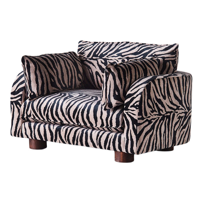 Zebra-patterned armchair in black and beige, featuring bold stripes and plush cushions for stylish comfort.