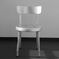 Modern silver chair with a minimalist design and smooth, polished surface. Ideal for contemporary spaces.
