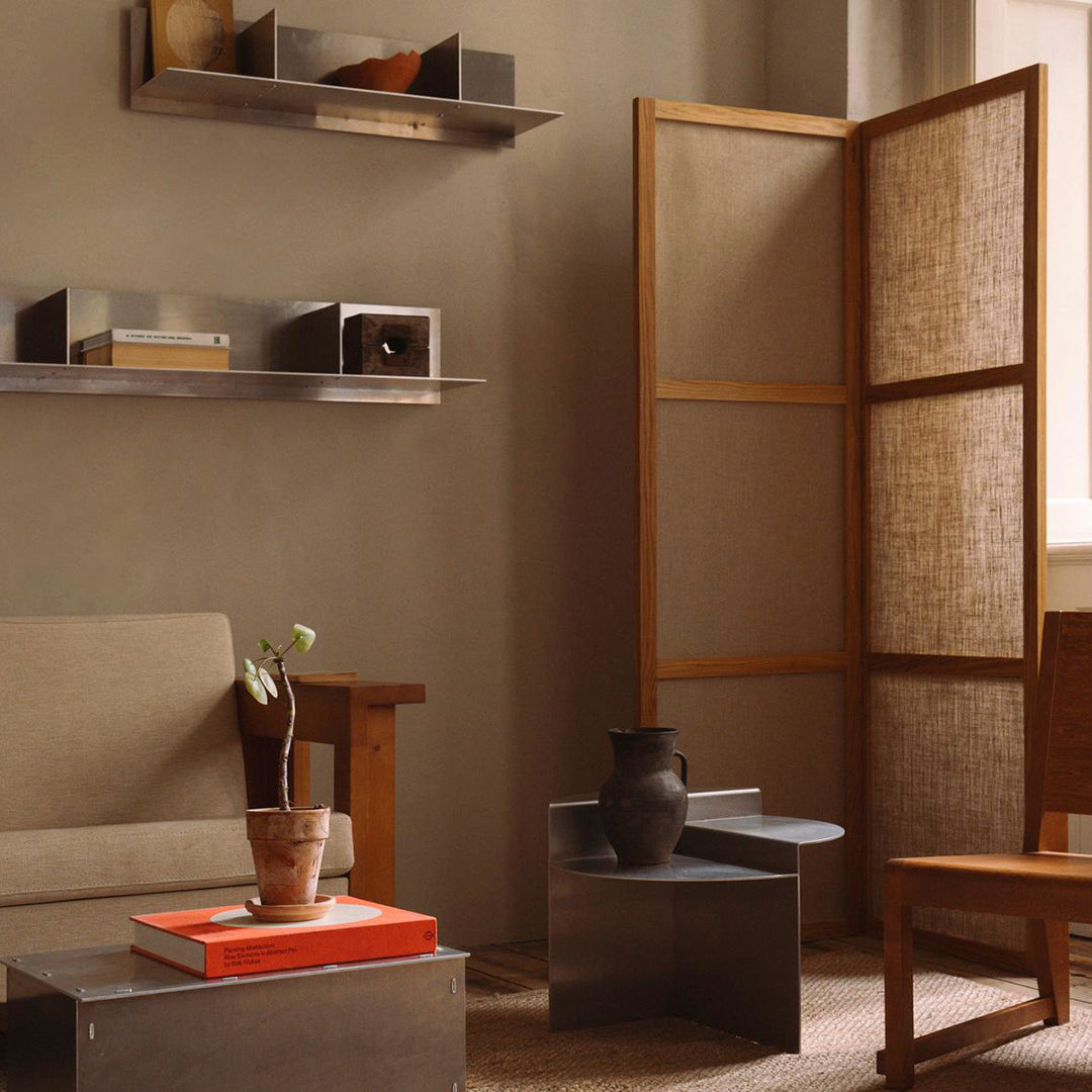 Neutral tones with warm wood accents, textured fabrics, and geometric patterns create a modern, cozy living space.