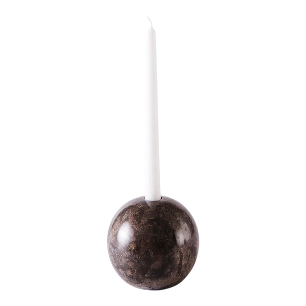 "White candle atop a stylish dark gray marble holder with a smooth finish."