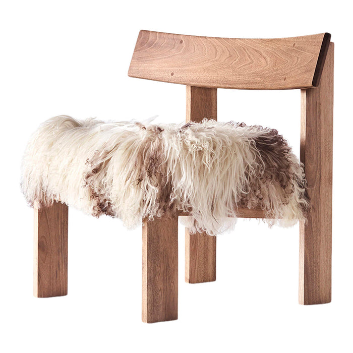 Wooden chair with soft, cream and brown fur seat, showcasing natural textures and earthy tones. Perfect for cozy decor.
