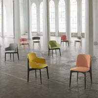 Colorful chairs in various hues: yellow, green, orange, gray, and black, against a bright, airy setting.