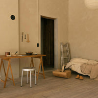 Warm beige walls, soft beige bedding, wooden tones, and subtle earth tones create a cozy, minimalist room ambiance.