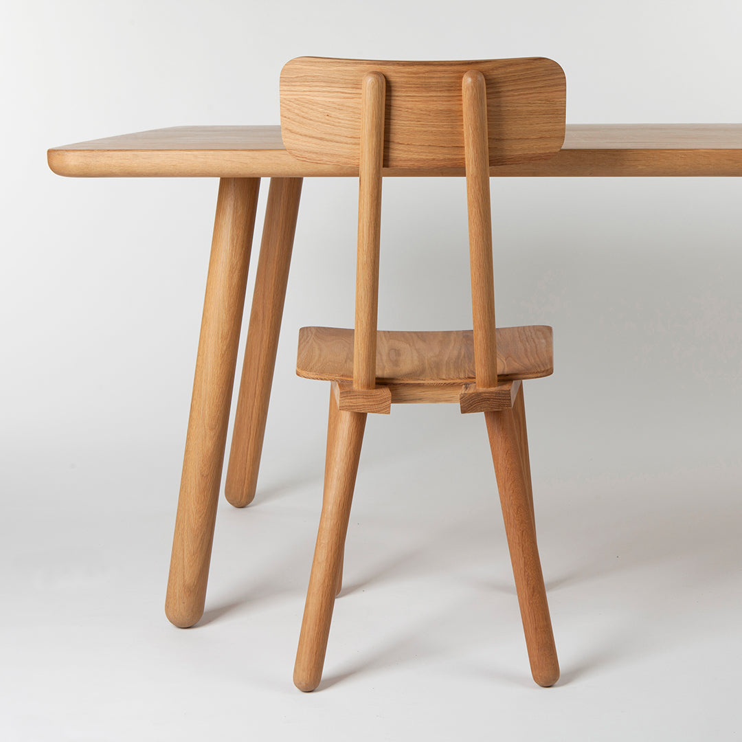 Natural wood dining table with a light finish, featuring smooth textures and minimalist design elements.