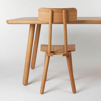 Natural wood dining table with a light finish, featuring smooth textures and minimalist design elements.