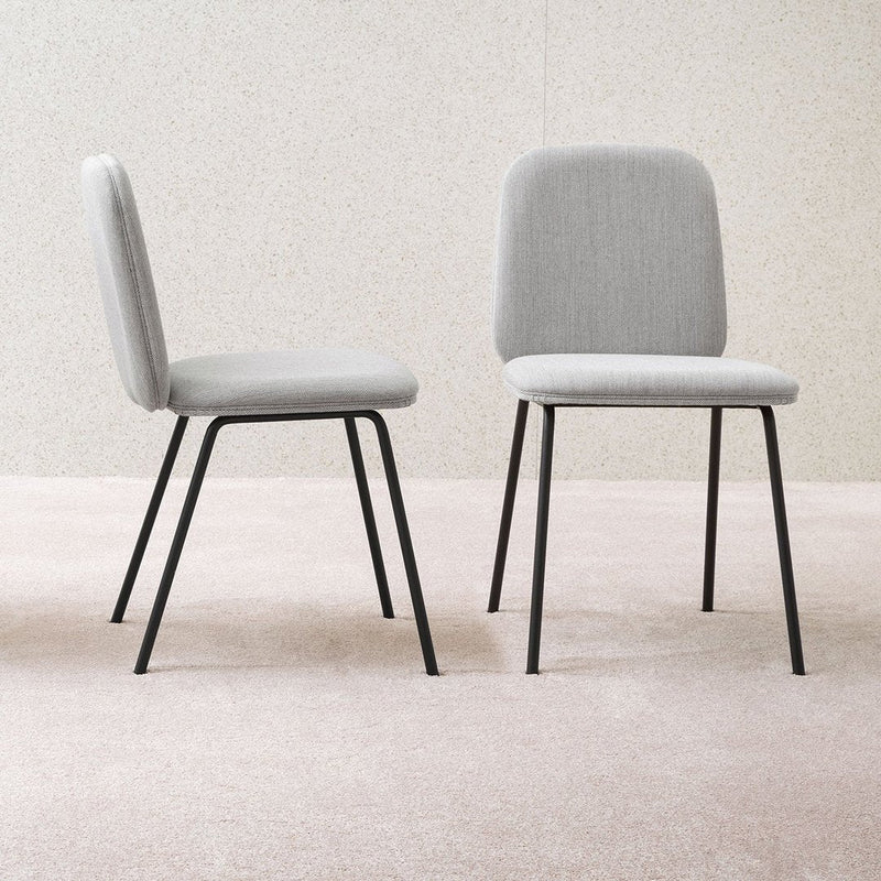 Two modern chairs in light gray upholstery with black metal legs, featuring a simple and minimalist design.