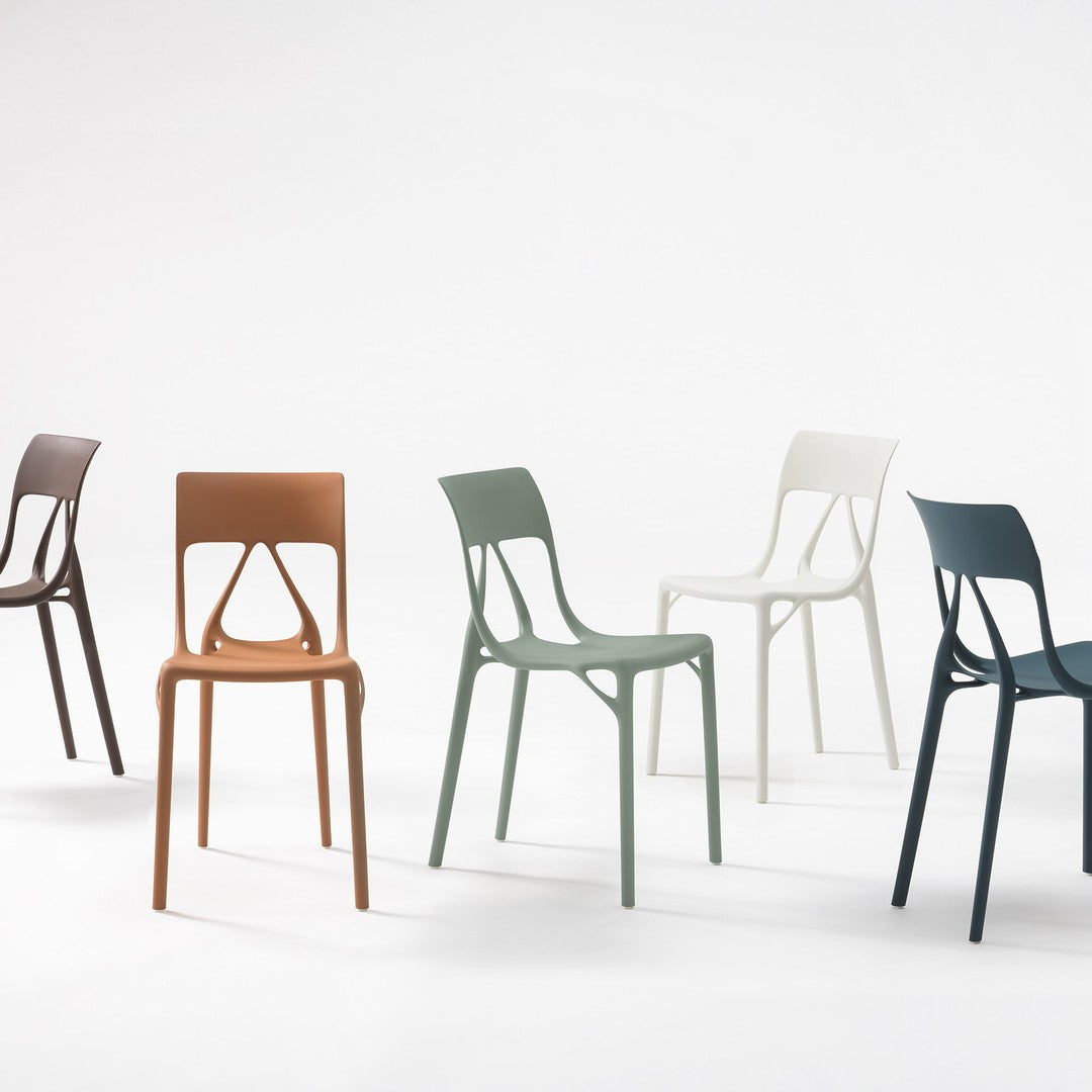 Colorful plastic chairs in dark brown, rust, sage green, white, and dark teal, showcasing a modern design and smooth textures.