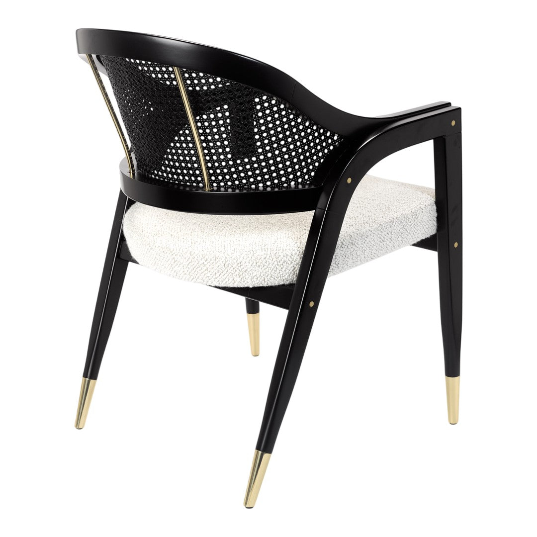 Black and gold accent chair with a woven back, featuring a textured white cushion and sleek legs. Stylish and modern design.