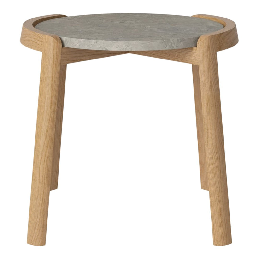 Light wooden legs support a round gray concrete tabletop with a smooth finish, showcasing minimalist design.