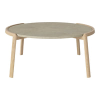 Round coffee table with a light wood frame and a textured grey stone top, showcasing a minimalist design.