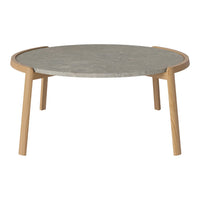 Round coffee table with a light wood frame and a smooth grey stone top, featuring a minimalist design.