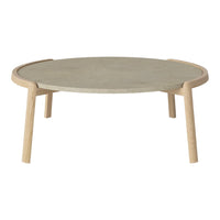 Round coffee table with a smooth gray top and light wooden legs. Minimalist design with a natural finish.