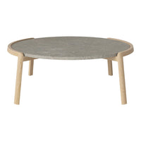Round coffee table with a smooth gray stone top and natural wood legs, featuring a minimalist design.