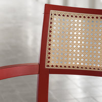 Red wooden chair with a woven natural cane pattern in the backrest, creating a modern and stylish look.