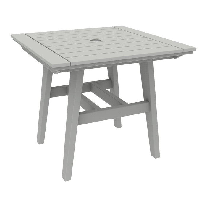 Gray slatted square outdoor table with a central hole for an umbrella, featuring a modern minimalist design.