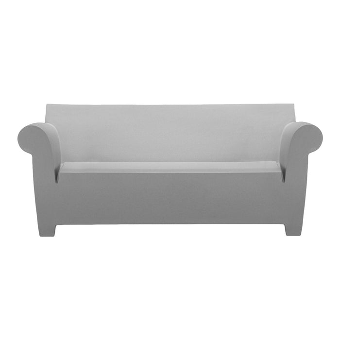 Gray minimalist sofa with smooth lines and rounded arms, perfect for contemporary decor.