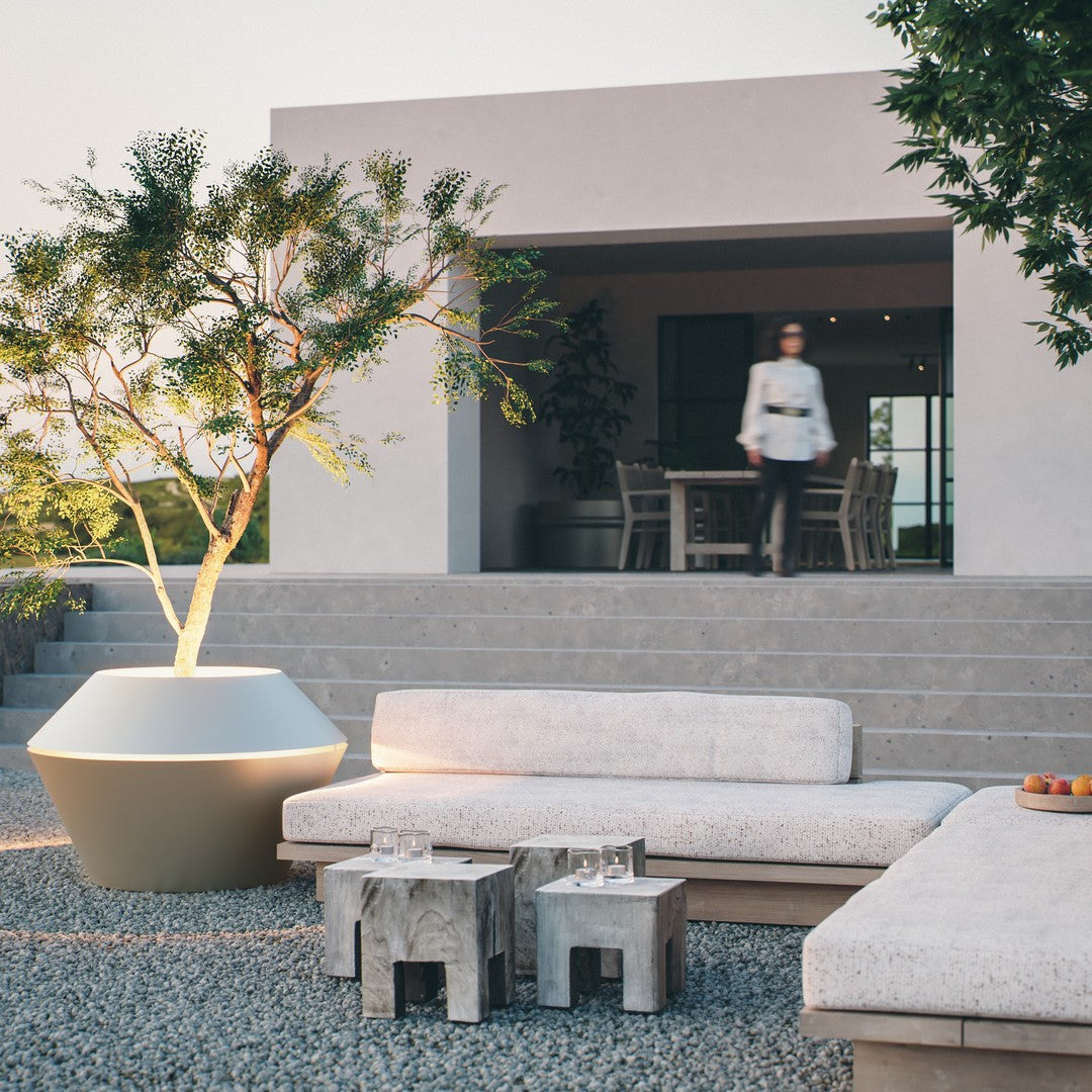 Modern outdoor lounge set featuring neutral beige cushions, natural wood accents, and a sleek white planter.