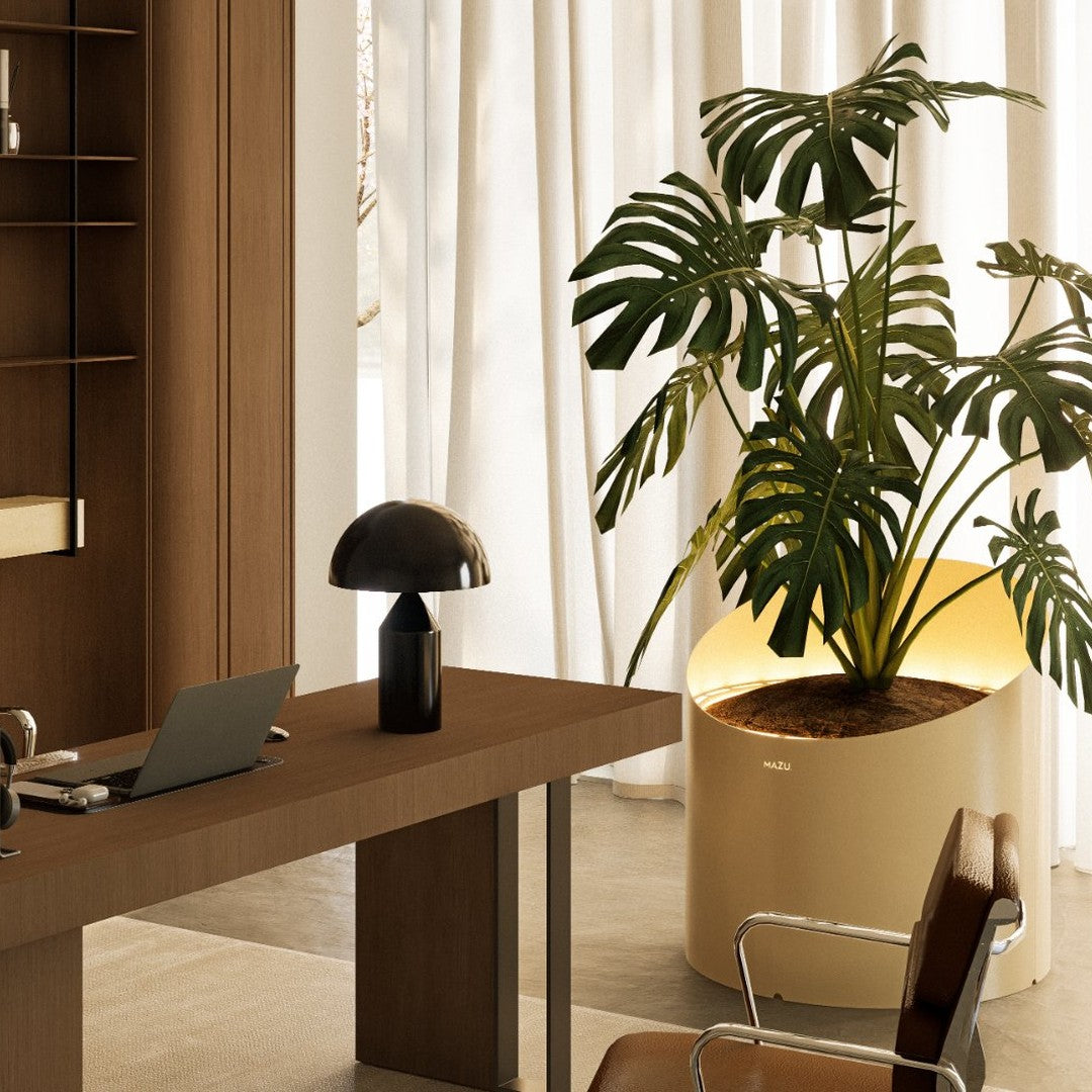 Elegant brown wood desk paired with a modern black lamp and vibrant green Monstera plant in a sleek beige pot.