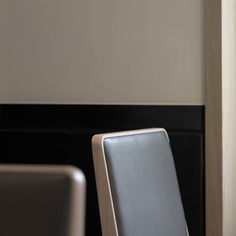 Stylish black and white chair with a sleek, modern design and smooth leather upholstery against a muted background.