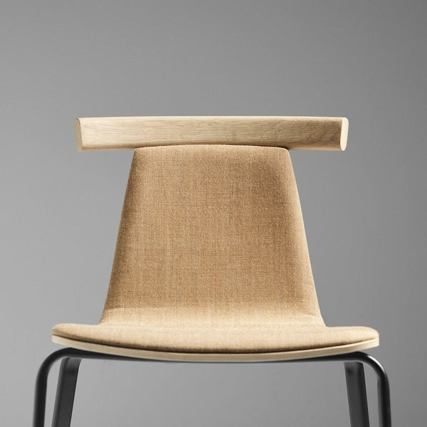 Minimalist beige chair with sleek black legs, showcasing a simple, modern design and clean lines.