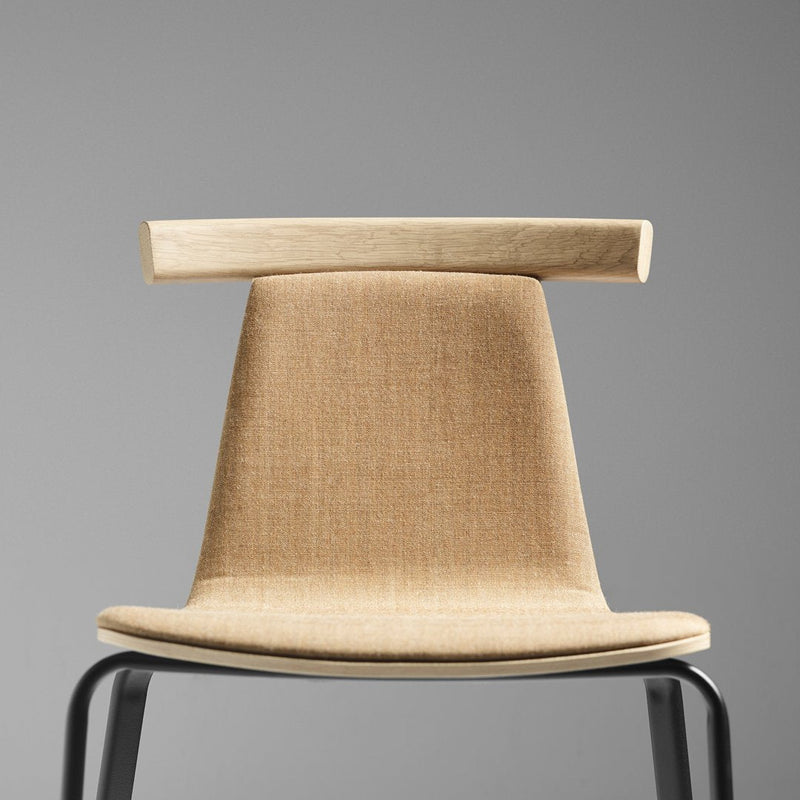 Minimalist beige chair with sleek black legs, showcasing a simple, modern design and clean lines.