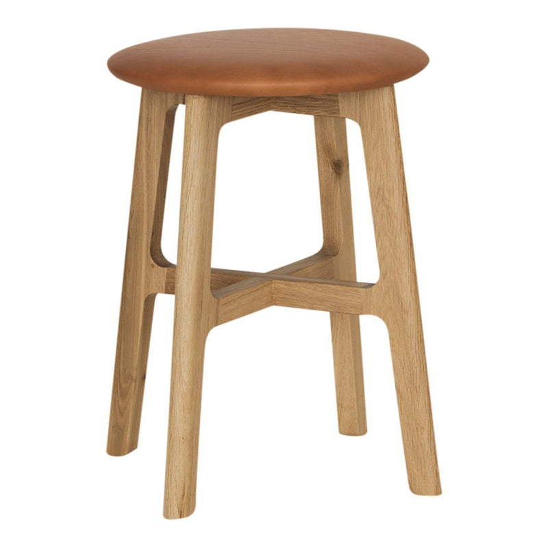 Wooden stool with a natural finish and a smooth, tan leather seat. Simple, modern design with a minimalist aesthetic.