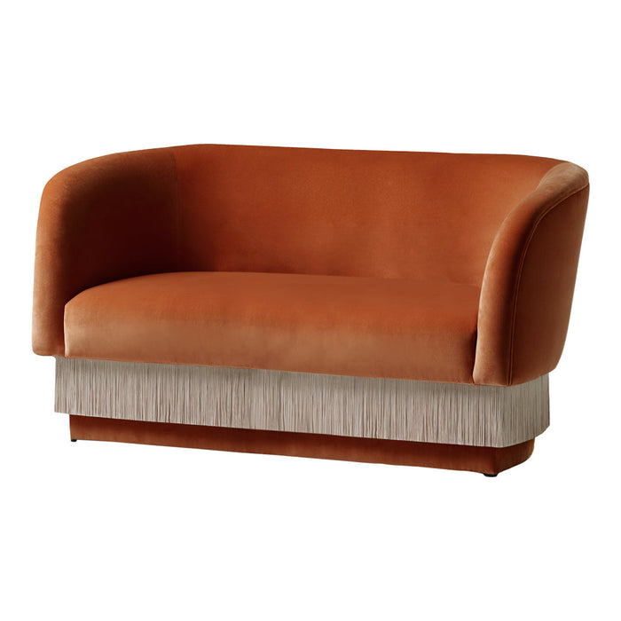 Rust orange velvet sofa with upholstered fringe detail in light neutral shades for a modern chic look.