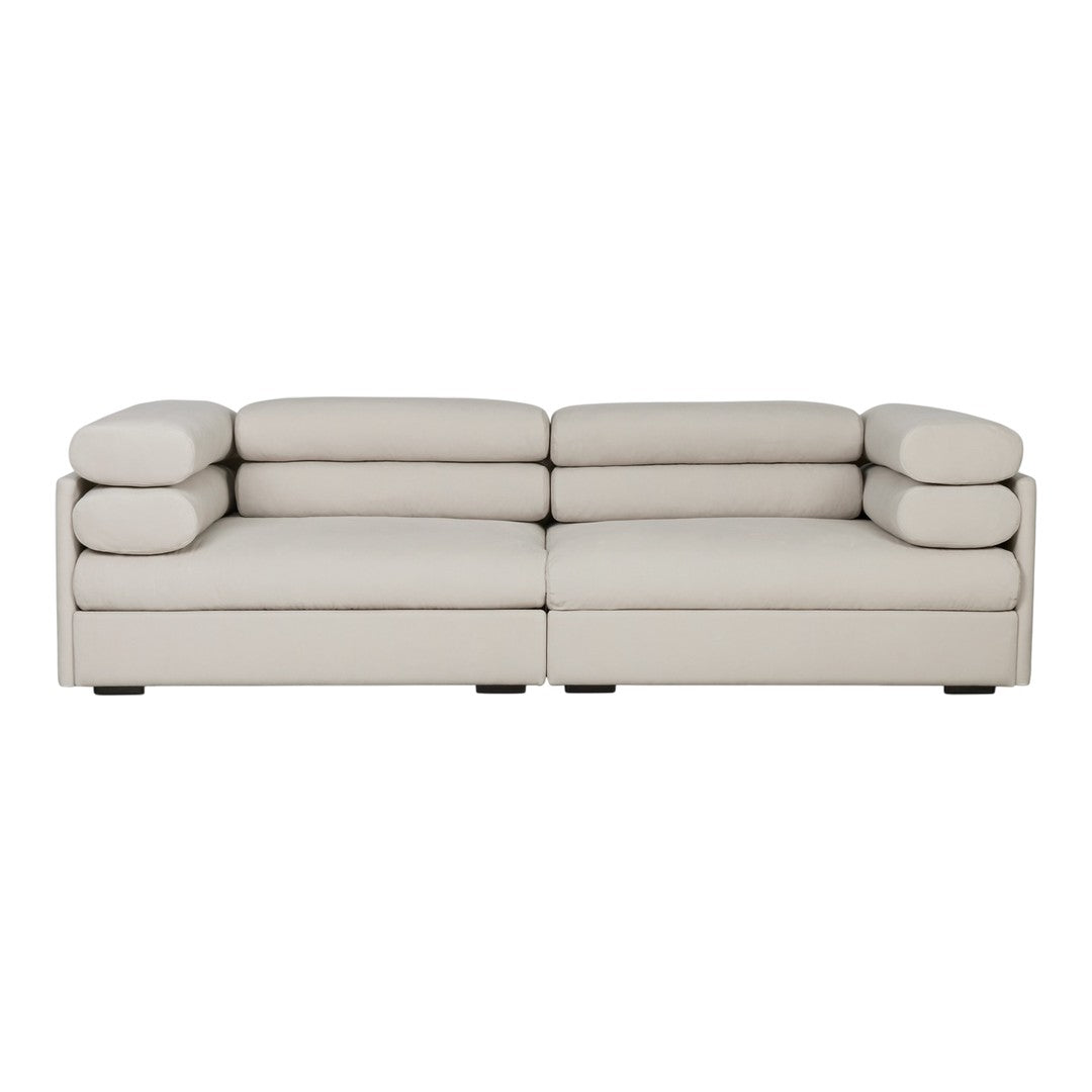 Soft beige sectional sofa with streamlined design and plush round cushions for contemporary living spaces.